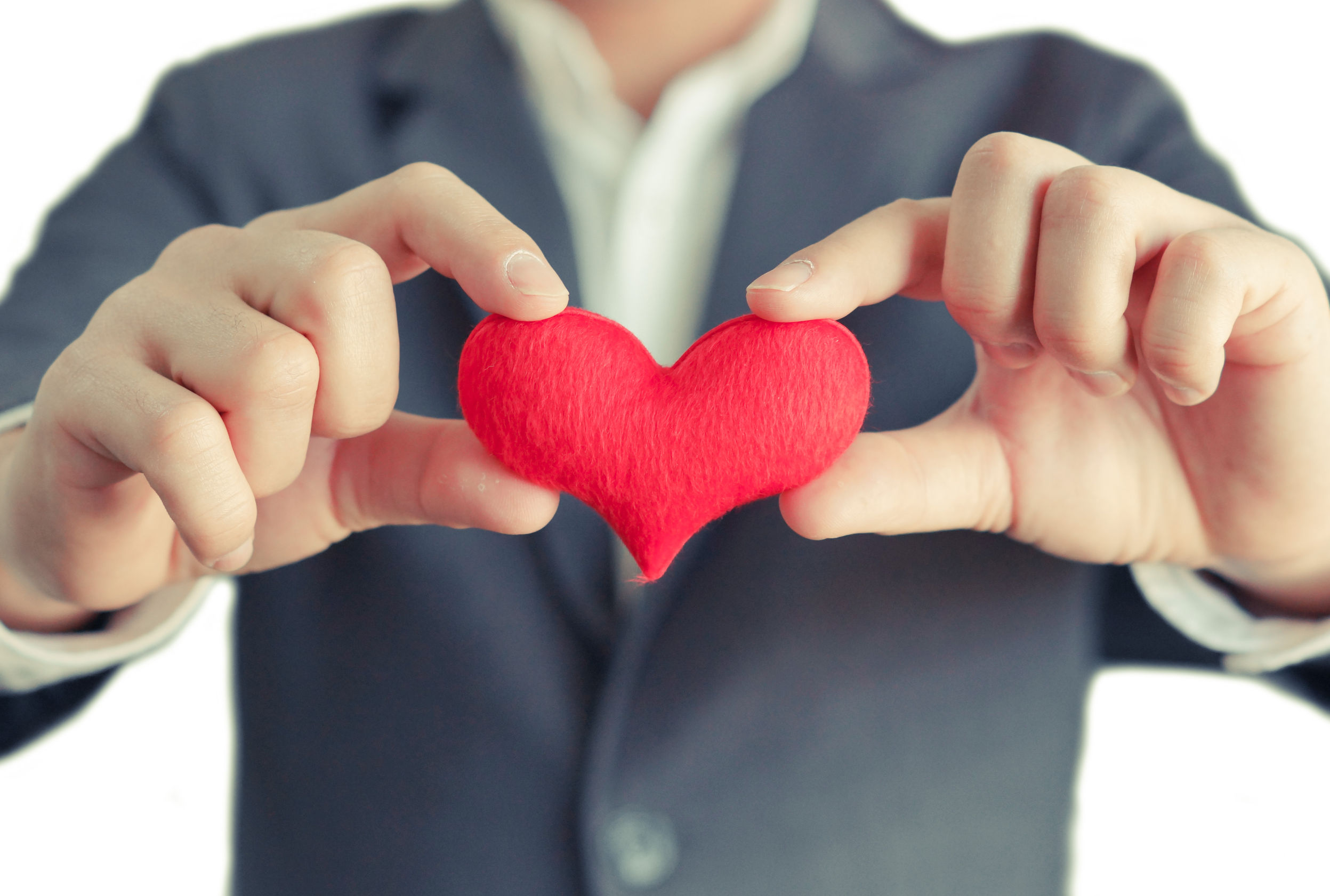 38767508 - hands of a businessman holding a red heart / service mind